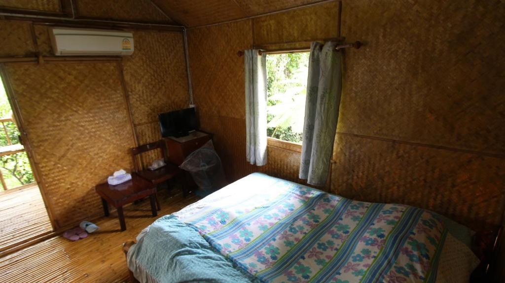 a bedroom with a bed and a window at Cast Away in Nonthaburi