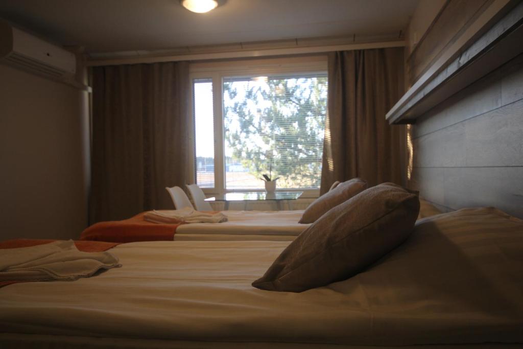 a bedroom with two beds and a window with a view at Jääskän Loma Apartment Hotel Härmä in Härmä