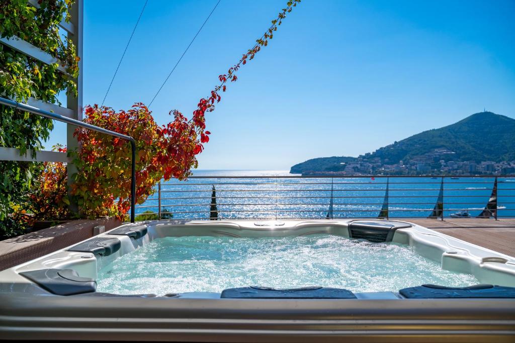 a hot tub on a balcony with a view of the water at Dukley Hotel & Resort in Budva