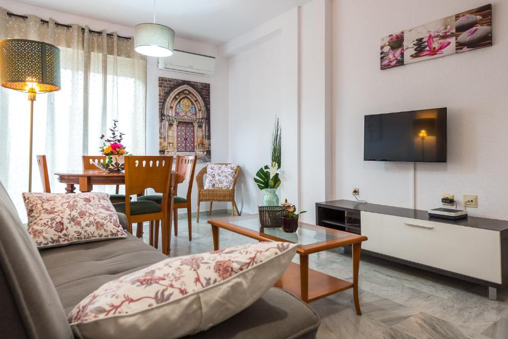 - un salon avec un canapé, une télévision et une table dans l'établissement Apartamentos Vado - Sendero del Veleta, à Cenes de la Vega