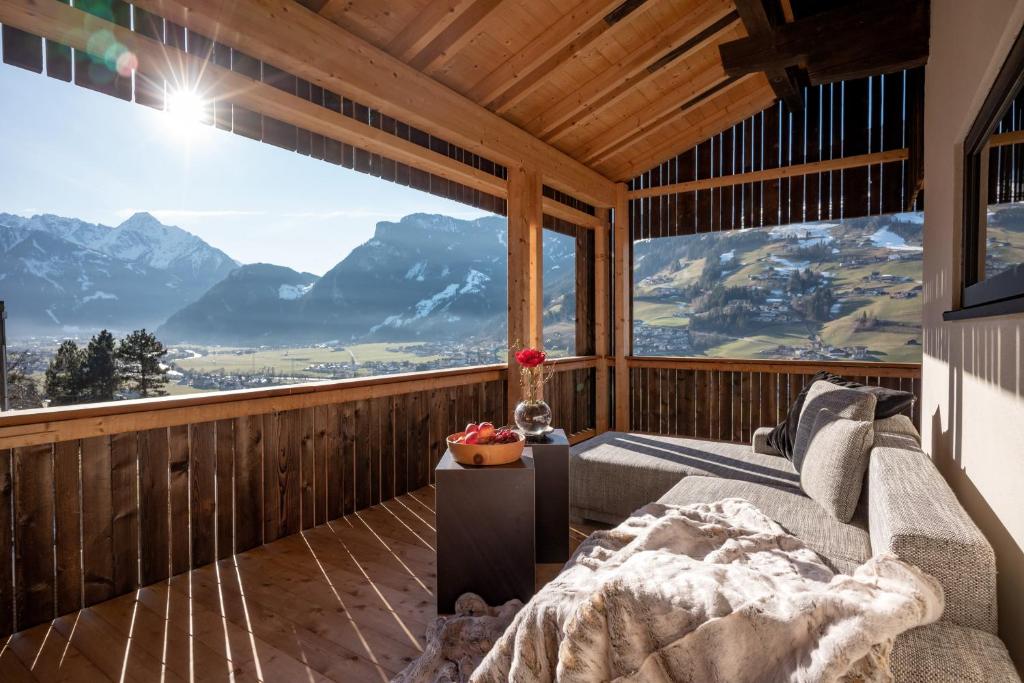 Habitación con cama y ventana grande con vistas a las montañas. en Apartments Zauberberg, en Hainzenberg