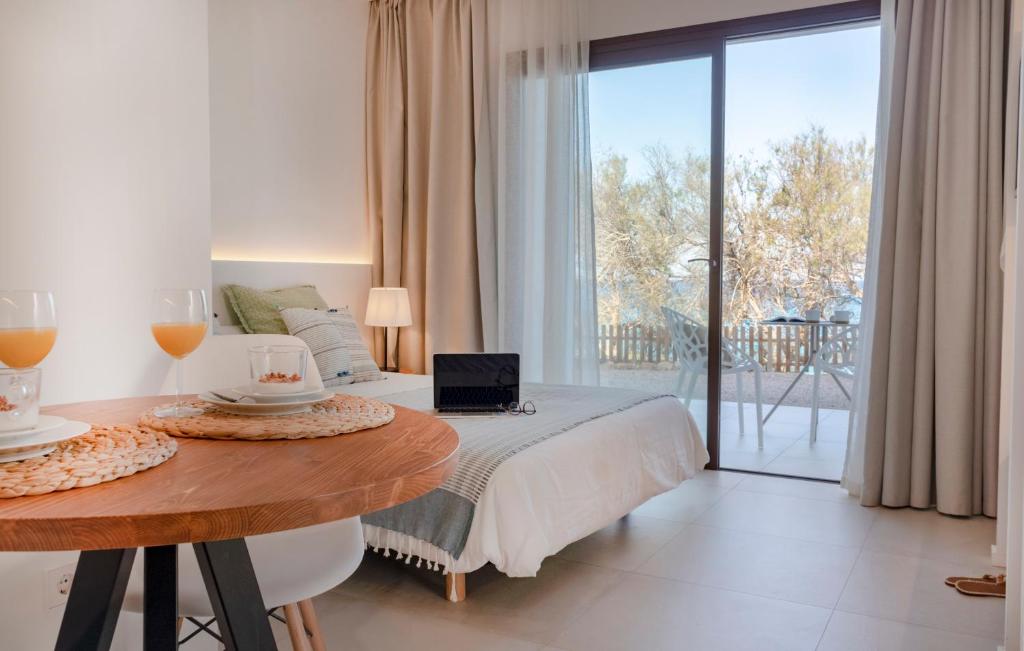 Un dormitorio con una cama y una mesa con un ordenador portátil. en Gaviota - Emar Hotels Adults Only, en Es Caló