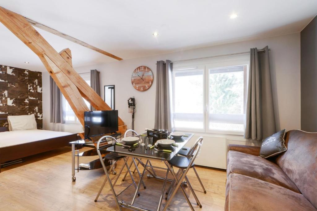 a living room with a table and a couch at Charming studio with parking in Sevrier along Annecy Lake - Welkeys in Sévrier