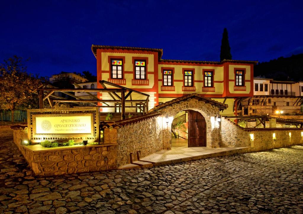 a building with a sign in front of it at night at Orologopoulos Mansion Luxury Hotel in Kastoria