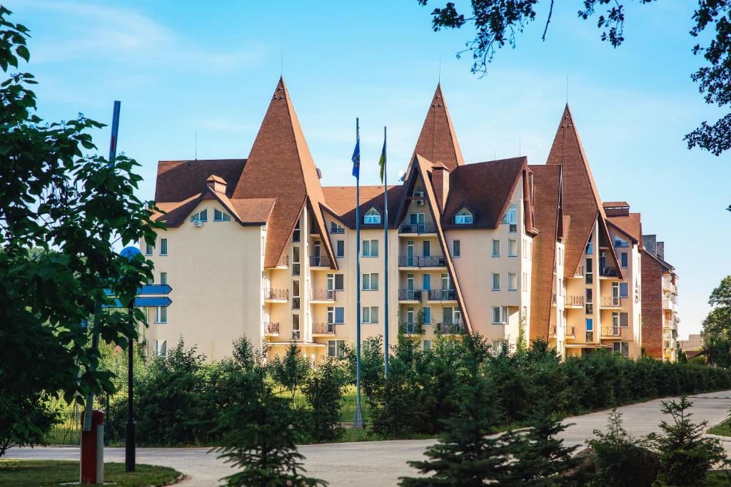 een groot gebouw met puntige daken in een park bij Apartament Hotel by Derenivska Kupil in Nyzhne Solotvyno