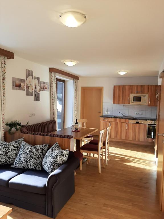 a living room and kitchen with a couch and a table at Bauernhof Burglehen in Wagrain