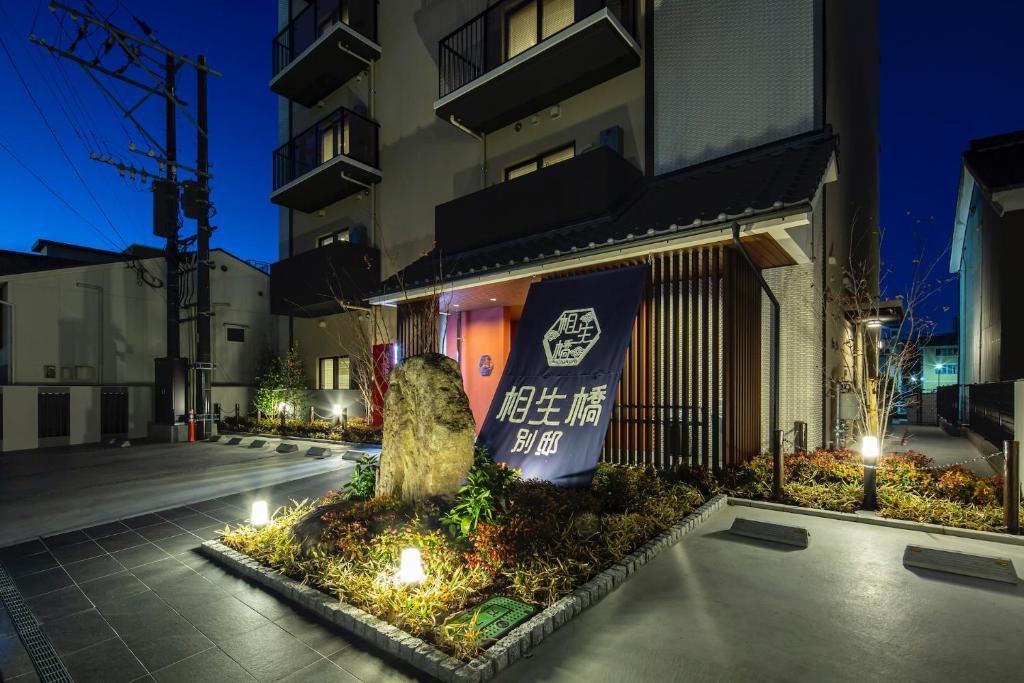 a building with a tree in front of a building at Hotel Imari Aioibashi Bettei in Imari