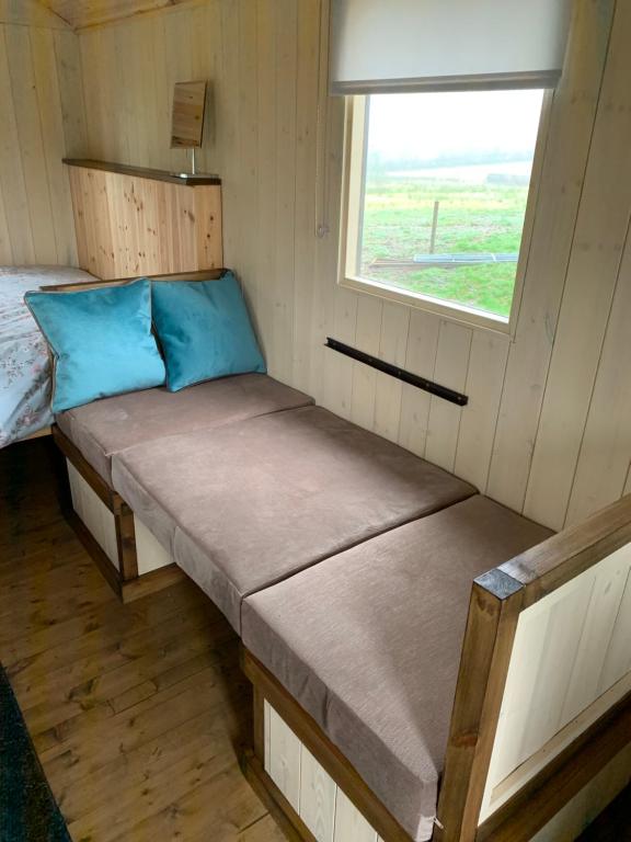 Una cama pequeña en una casa pequeña con ventana en Glamping at Holly Grove Farm, en Stoke on Trent