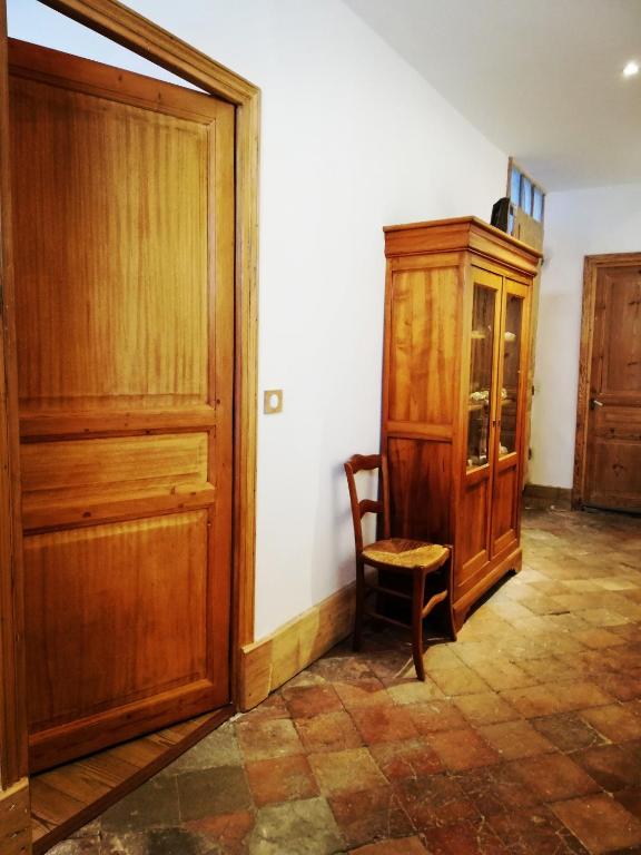 Cette chambre comprend une armoire en bois et une chaise. dans l'établissement L'usine, à Pont-de-Labeaume