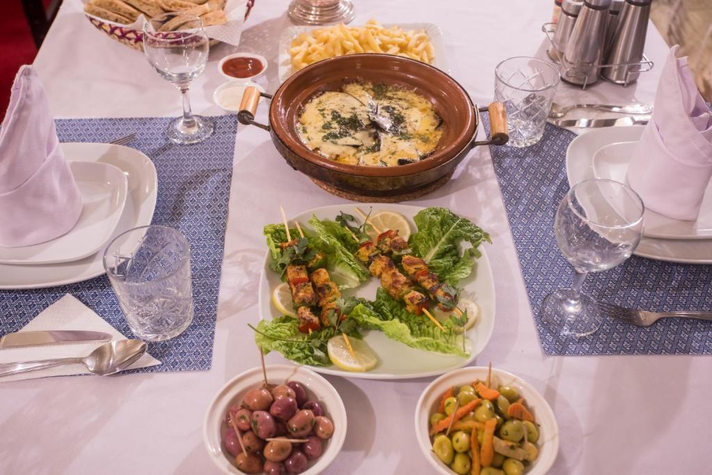 a table with plates of food and a pot of food at Luxury Desert Camp Amanar in Merzouga