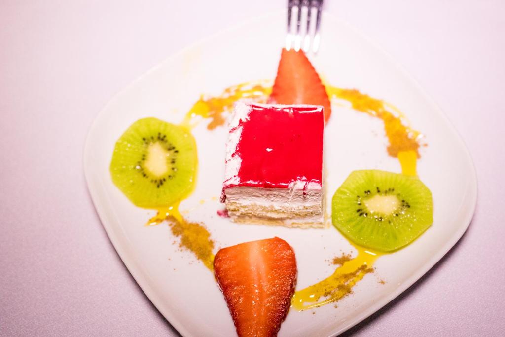 a white plate with a piece of cake and fruit at Luxury Desert Camp Amanar in Merzouga