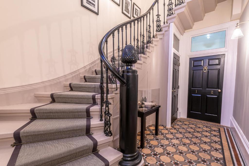 a staircase in a home with a black door at Newly Converted Apartment Rowntree House Shambles in York
