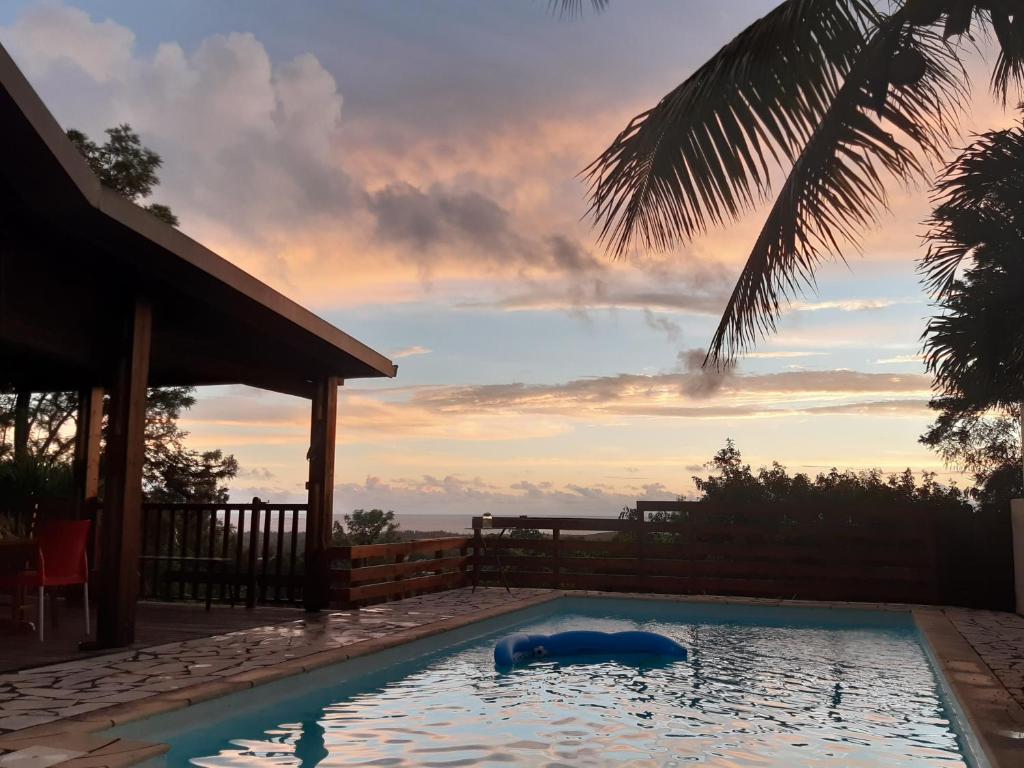 a swimming pool with a sunset in the background at Suite exotique in Étang-Salé
