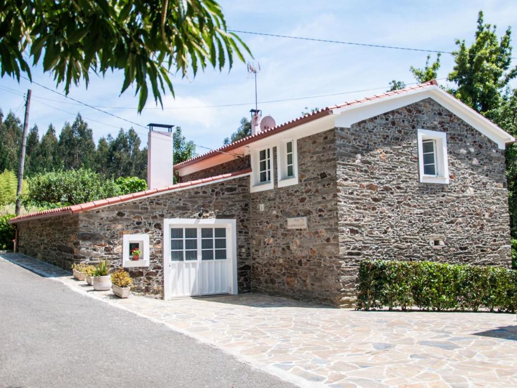 a stone house with a white garage at Holiday Home El Olivo in Puentedeume