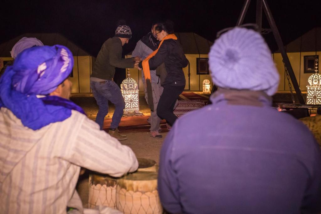 a group of people looking at a group of people at Luxury Desert Camp Amanar in Merzouga