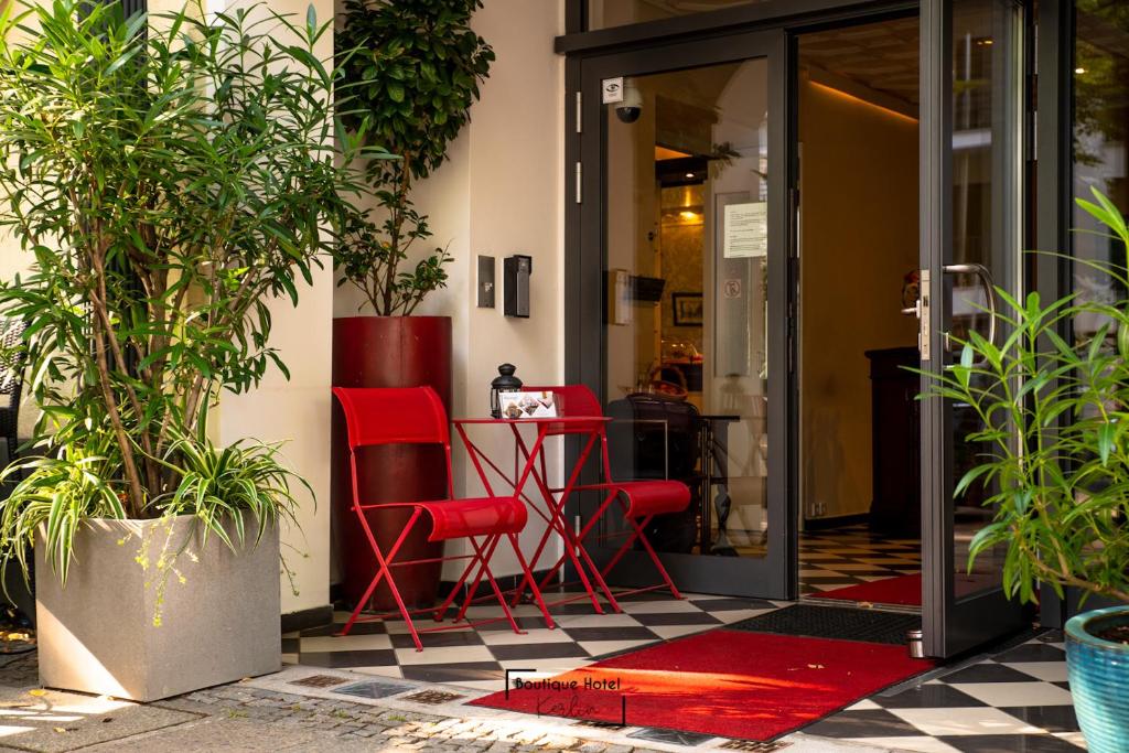 twee rode stoelen en een tafel op een patio bij Boutique Hotel Kerlin in Berlijn
