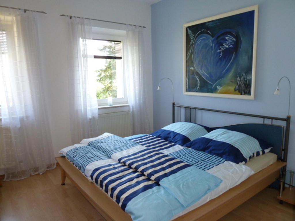 a bedroom with a bed with blue and white sheets at Ferienwohnung BEER in Mauth