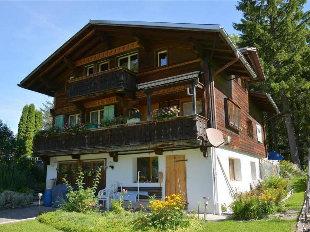 a wooden house with a balcony on top of it at Apartment Sonnegg by Interhome in Gsteig