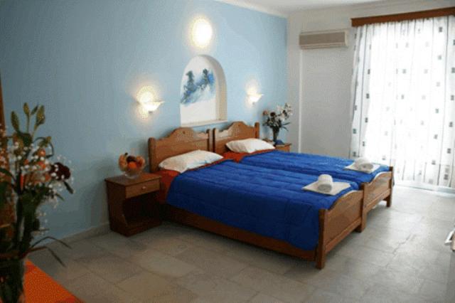 Un dormitorio con una cama grande con paredes azules. en Mike's Studios, en Naxos Chora
