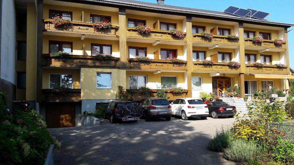 a large building with cars parked in front of it at Strandpension Liane in Sankt Kanzian