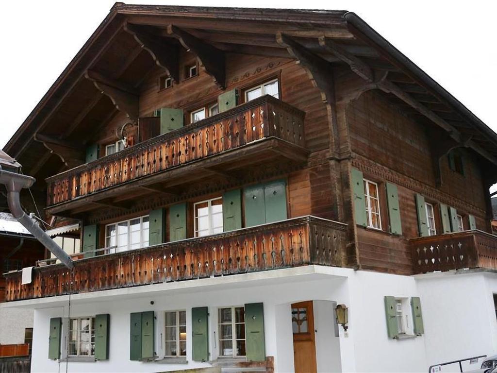 een groot houten gebouw met een balkon bij Apartment Oehrli by Interhome in Gstaad