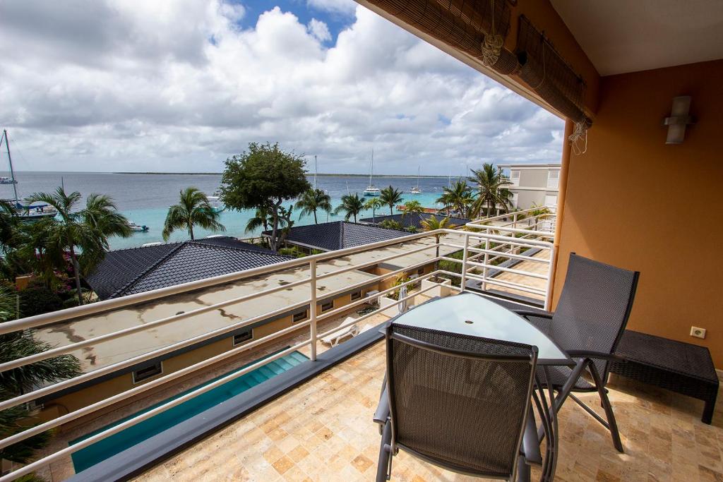 a balcony with a table and chairs and the ocean at Seaside Apartment Flamingo in Kralendijk