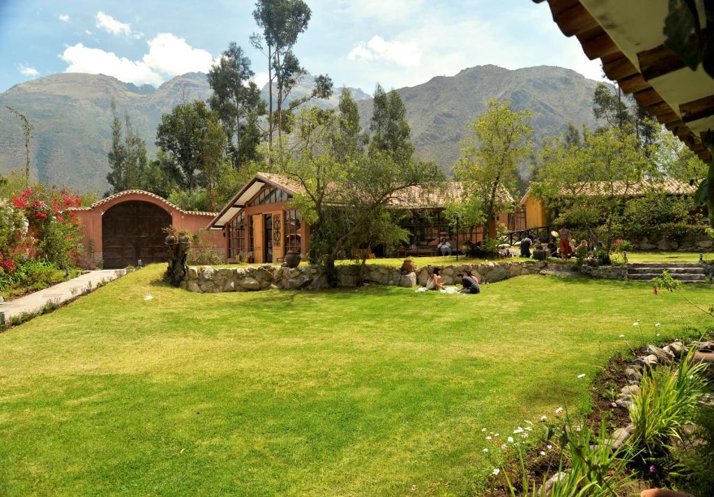 un gruppo di persone sedute sull'erba in un cortile di Andean Wings Valley a Urubamba