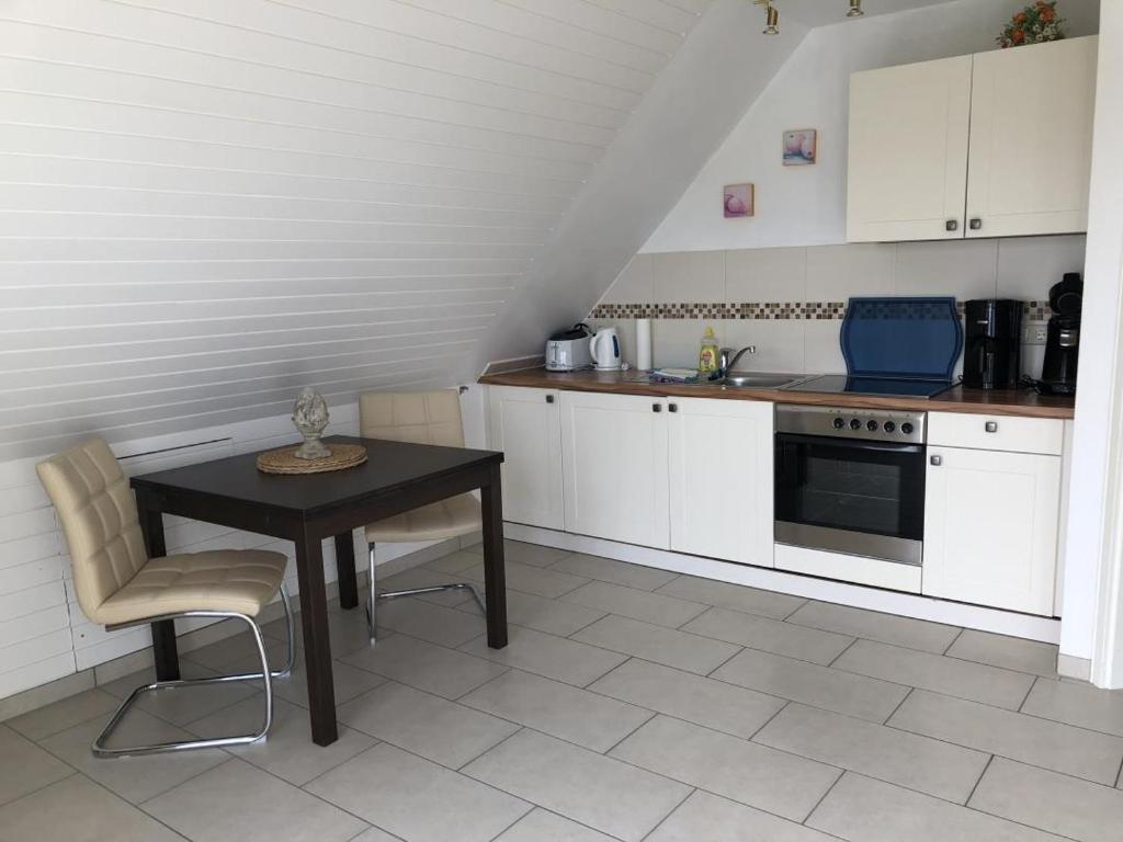 een keuken met een tafel, een wastafel en een fornuis bij Nixe in Scharbeutz