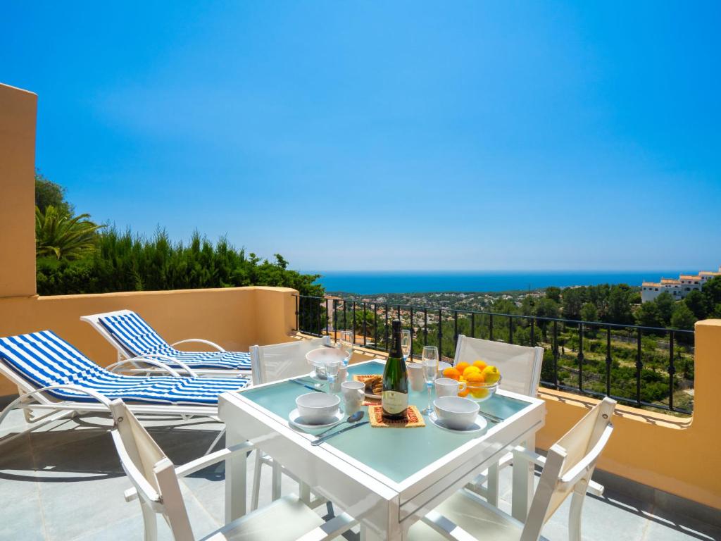 a white table and chairs on a balcony with the ocean at Apartment Miramar by Interhome in Moraira