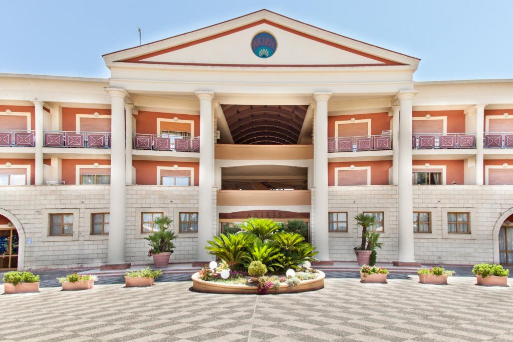 a large building with columns and plants in a courtyard at Centro Turistico Akiris in Nova Siri Marina