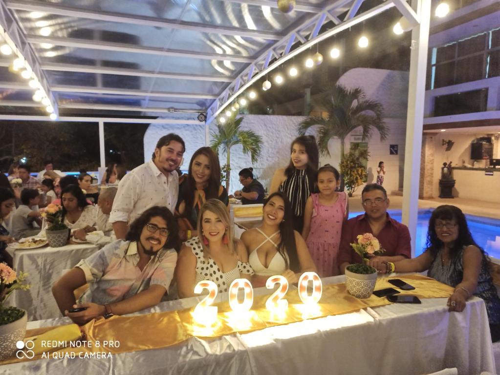 eine Gruppe von Menschen, die um einen Tisch mit Kerzen stehen in der Unterkunft Hotel Paradise Beach in Playas