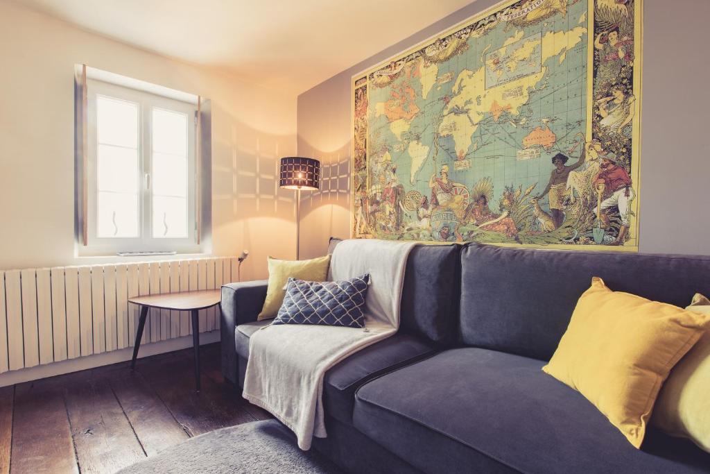un soggiorno con divano blu e una mappa sul muro di La Maison de la Liberté Studio Jules Verne a Poitiers