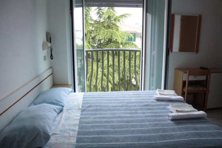 a bedroom with a bed with towels on top of it at Hotel Delizia in Rimini