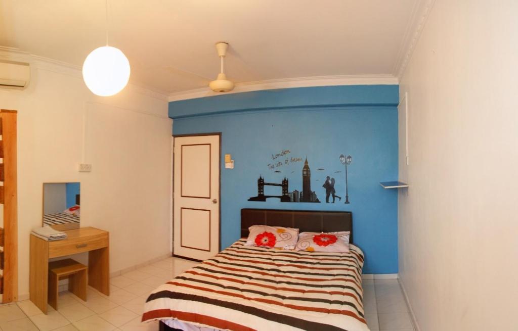 um quarto com uma cama com uma parede azul em DT Homestay floor level 4 em Malaca