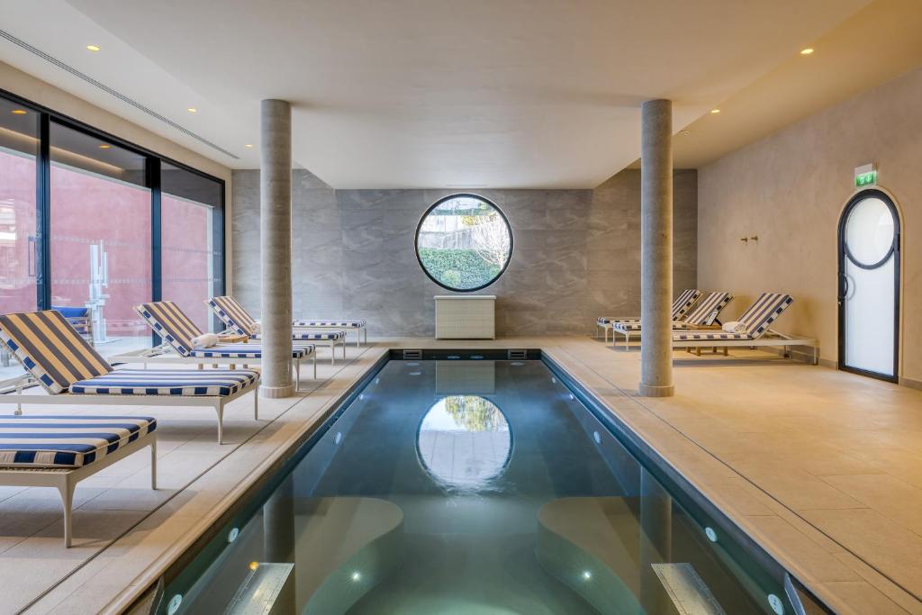 uma piscina num quarto com cadeiras e uma piscina em Maison Albar Hotels L’Imperator em Nîmes