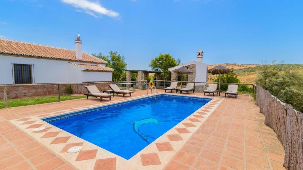 a swimming pool in the backyard of a house at Casa Rural El Guindo in Málaga