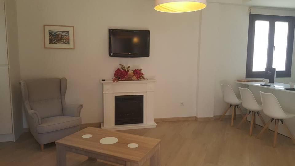 a living room with a fireplace and a tv on the wall at Apartamento Palacio Azcárate Marisa Sanchez in Ezcaray