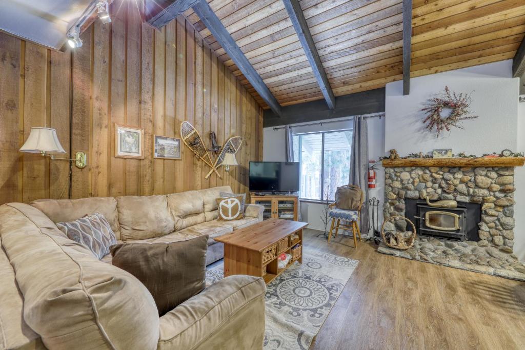 a living room with a couch and a stone fireplace at Sunshine Sanctuary in Mammoth Lakes