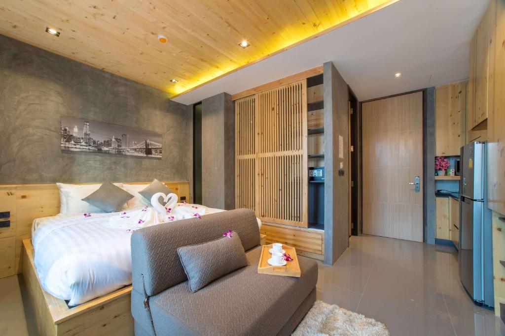 a bedroom with a bed and a couch and a refrigerator at Лофт-студия 10 минут до пляжа B228 by IBG Property in Nai Harn Beach
