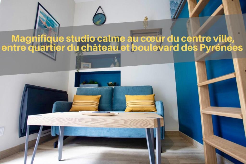 uma sala de estar com um sofá azul e uma mesa em Tiny Stud em Pau