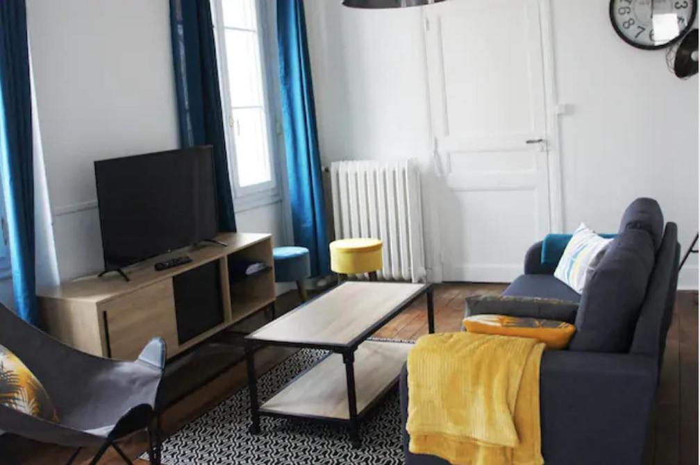 un salon avec un canapé bleu et une télévision dans l'établissement Bel appartement ancien Poitiers Centre - 4 Chambres, à Poitiers