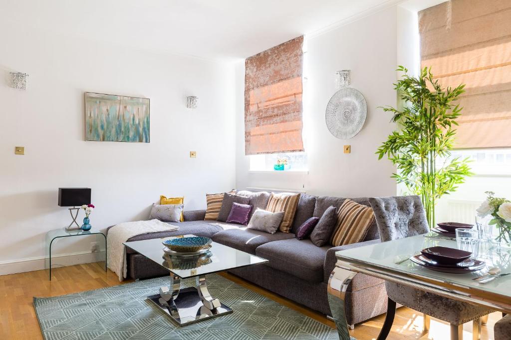 - un salon avec un canapé et une table dans l'établissement PickThePlace Apartment behind Selfridges, à Londres