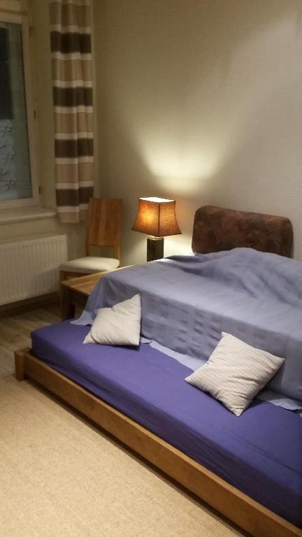 - une chambre dotée d'un lit bleu avec une lampe et une chaise dans l'établissement 1-Raum Wohnung Eiche, à Zittau