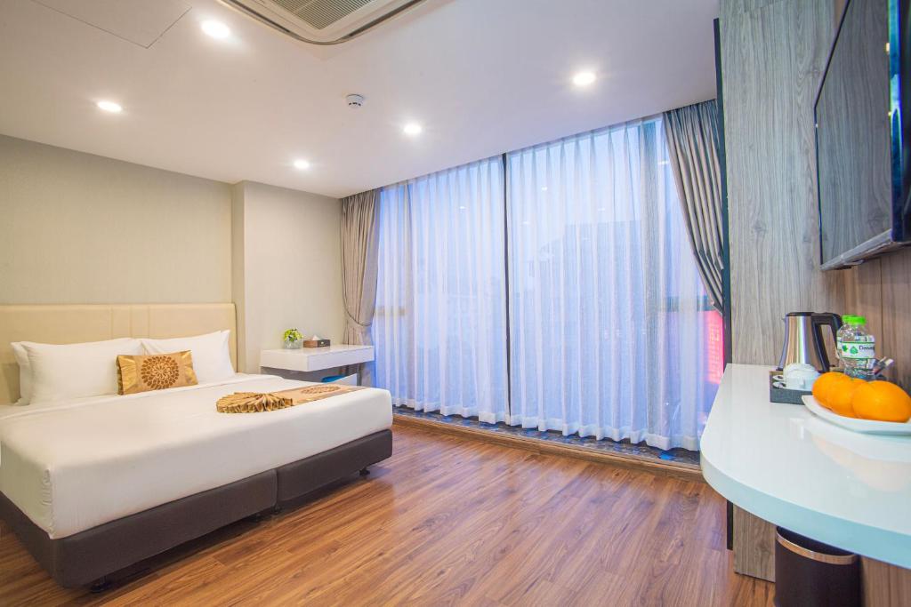 ein Schlafzimmer mit einem Bett und einem großen Fenster in der Unterkunft Bridge Lakeside Room For Rent Hanoi in Hanoi