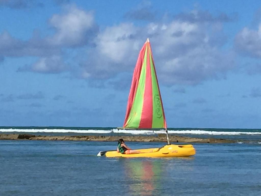 a person riding a sail boat with a sail at Nannai Beira Mar Porto de Galinha 207 in Porto De Galinhas