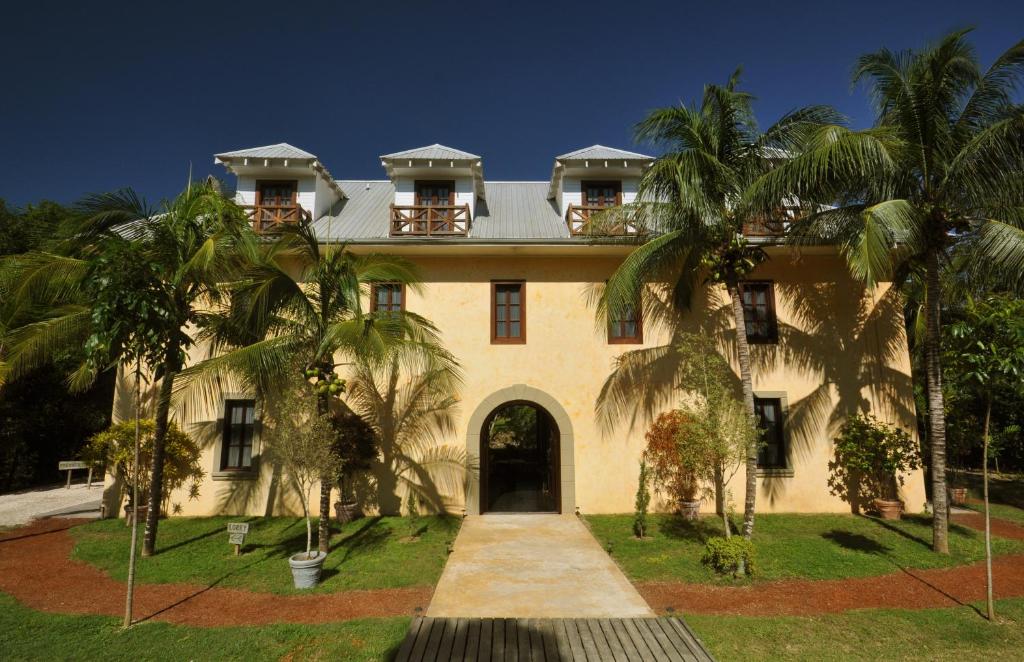 a large house with palm trees in front of it at Mahogany Hall Luxury Boutique Resort in San Ignacio
