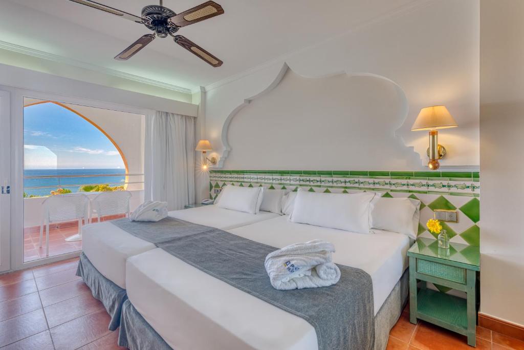 um quarto com uma cama e vista para o oceano em Playacálida em Almuñécar