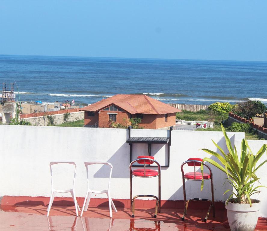清奈的住宿－Kolam Elliots Beach，阳台上配有两把椅子和一张桌子,享有海景