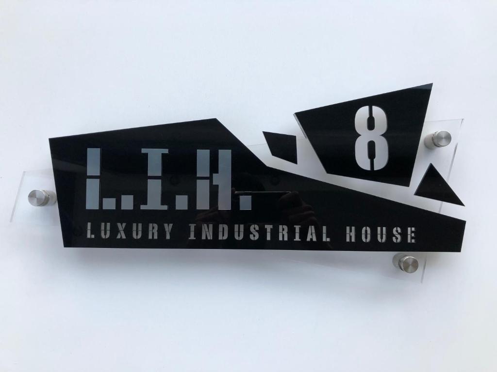 a black sign for a luxury industrial house at (L.I.H.8) Luxury Industrial House 8 in Nea Paphos