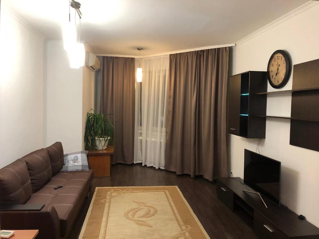 sala de estar con sofá y reloj en la pared en Затишна 2х кімнатна квартира біля метро Академмістечко, en Kiev